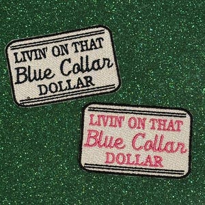 May include: Two rectangular patches with the text "LIVIN' ON THAT Blue Collar DOLLAR". One patch has black text, the other has pink text. Both patches have a white background and black border. The background is a sparkly green.