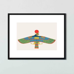 May include: A framed print of an Egyptian god depicted as a winged falcon with a red sun disk above its head. The falcon is blue, green, and yellow with red and gold accents.