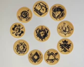 Pode incluir: Dez  tapetes redondos de madeira com desenhos em preto e branco. Os desenhos incluem um coração, uma coroa, um pássaro, uma chama e um padrão geométrico.