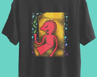 May include: Black t-shirt featuring a red cartoon figure with a yellow and orange background. The figure is holding a green object. The design is surrounded by colorful stars and green objects.