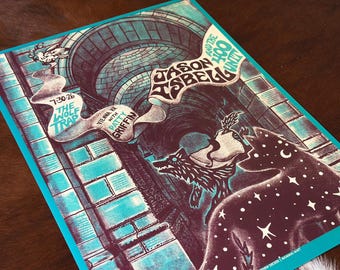 May include: A rectangular concert poster featuring a teal and dark purple color scheme. The artwork depicts a stone archway, two wolves, and a flowing banner with the text Jason Isbell and the 400 Unit, 7-30-26, The Wolf Trap, and Patty Griffin.