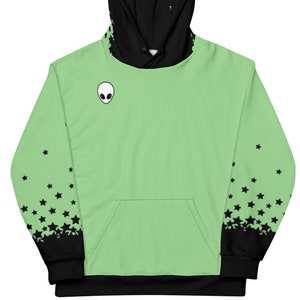May include: A green hoodie with a black alien face graphic on the front and black stars on the sleeves. The hoodie has a black hood and black drawstrings.