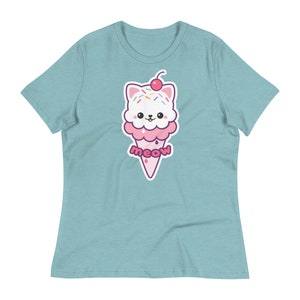 K&ouml;nnte beinhalten: Hellblaues T-Shirt mit einem Cartoon-Eiswaffel-Design mit einem Katzenkopf. Das Eis hat rosa und wei&szlig;e Schichten, Streusel und eine Kirsche. Das Wort "meow" steht auf dem Eisbecher.
