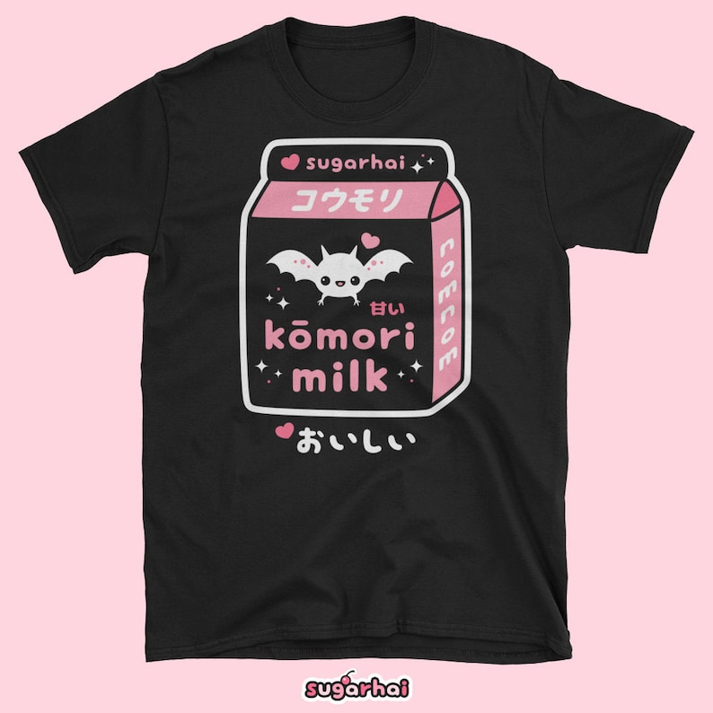 May include: Black t-shirt featuring a pink and white graphic of a milk carton with a bat illustration and Japanese text. The text includes "sugarhai", "kōmori milk", and "delicious". The shirt has a crew neck.