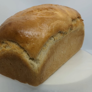 May include: A loaf of white bread, freshly baked and golden brown.