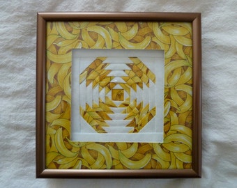 May include: A framed artwork featuring a white geometric pattern against a background of yellow banana peels.