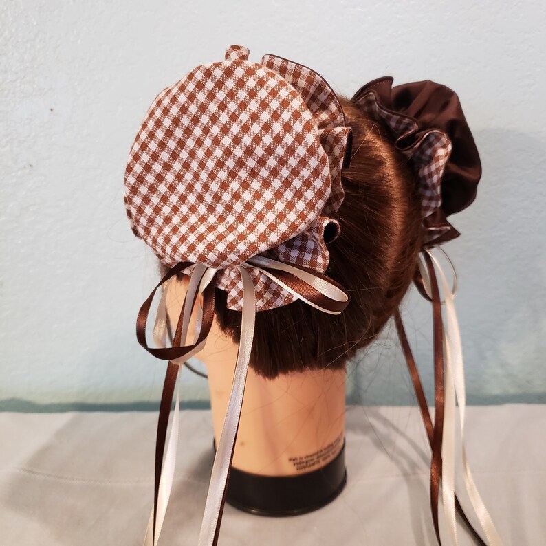 May include: Brown and white gingham fabric hair bonnet with white and brown satin ribbons.