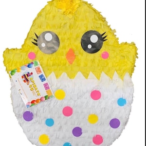 May include: A yellow chick-shaped piñata with a white eggshell base. The chick has large eyes, eyelashes, and an orange beak. The eggshell is decorated with colorful polka dots. A small card is attached to the piñata.
