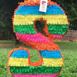 May include: A colorful, multi-layered, paper mache piñata shaped like the number 8. The piñata is decorated with orange, yellow, green, blue, and pink tissue paper.