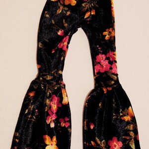 May include: Black velvet bell bottom pants with a floral pattern in shades of orange, yellow, and pink.