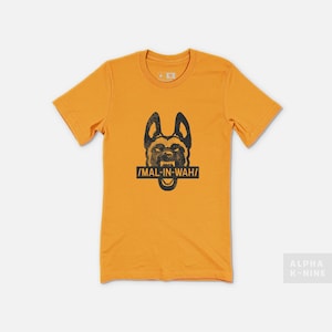 May include: A yellow t-shirt with a black and white illustration of a dog's head with the text "MAL-IN-WAH" printed on it.