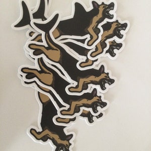 May include: A collection of stickers featuring a German Shepherd dog in a running pose with an open mouth, showing its teeth. The stickers have a black and tan color scheme with a white border.