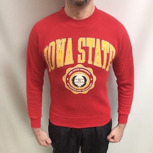 Könnte beinhalten: Rotes Sweatshirt mit einem gelben und weißen Logo der Iowa State University. Das Logo zeigt die Worte "Iowa State University" und "Science and Practice of Science and Technology".