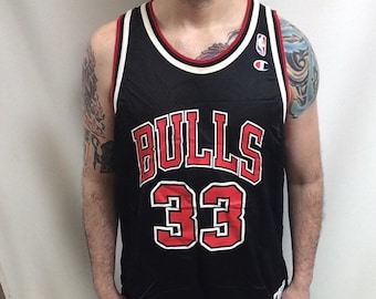 May include: Black basketball jersey with white and red trim. The jersey has "BULLS" in red lettering and the number "33" in white lettering with a red outline. The Champion logo is on the right shoulder.