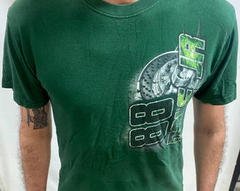 May include: Green short-sleeved t-shirt with a graphic design. The graphic features the number "88" in white and green, and a car part image. The shirt has a crew neck.