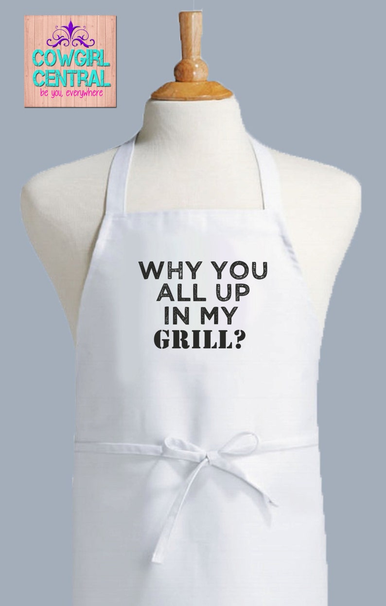 May include: White apron with black text that reads "Why you all up in my grill?"