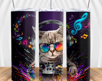 May include: A stainless steel tumbler with a colorful design featuring a cat wearing headphones and sunglasses, holding a DJ mixer. The background is black with colorful paint splatters and musical notes.
