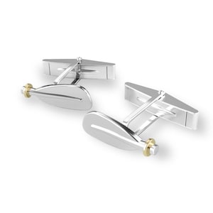 May include: Silver cufflinks with a gold accent in the shape of an oar.