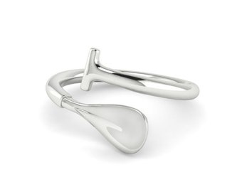 May include: A silver ring with a paddle-shaped design. The ring is open and has a curved shape.