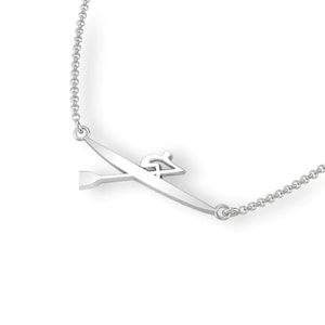 Peut inclure: Collier en argent avec un pendentif en forme de rameur. Le pendentif représente une figure stylisée en train de ramer dans un bateau avec une rame.