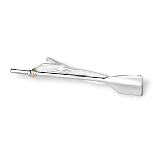 May include: Silver tie clip with a gold ring and a silver oar design.