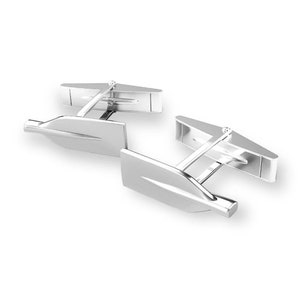 May include: A pair of silver cufflinks shaped like oars, a traditional symbol of rowing.