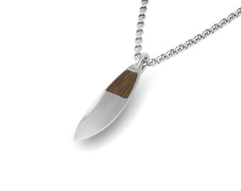 May include: A silver chain necklace with a surfboard pendant. The pendant is made of silver and has a wood inlay.