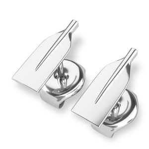 May include: A pair of silver earrings shaped like oars. The earrings are designed to look like a traditional rowing oar.