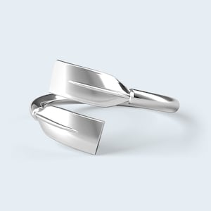 May include: Silver ring shaped like two crossed oars, a popular design for rowing enthusiasts.