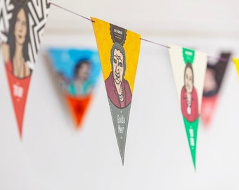 May include: A colorful string of triangular flags with portraits of women. Each flag has a different color and design. The flags are hanging from a string. The text on one flag reads "Golda Meir".