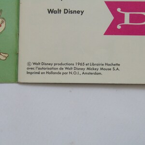 May include: Vintage Walt Disney book cover featuring a green airplane with a mouse pilot and a brown puppy. The cover includes the text "Walt Disney" and a pink flag with a white "D". Copyright information is also visible.