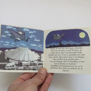 May include: A vintage children's book featuring illustrations of Dumbo the elephant. The open pages show Dumbo flying at night, with a circus tent in the background. The book has a green border.