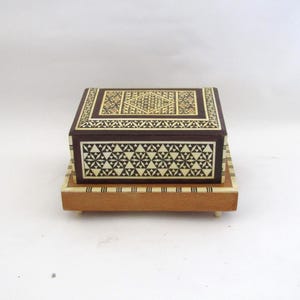 Puede incluir: Un juego de tres tazas de cerámica con un acabado moteado y mate. Las tazas son de color crema, gris claro y gris oscuro. Cada taza tiene un diseño simple y minimalista y un asa redondeada.