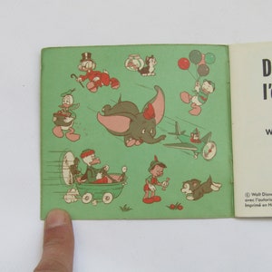 May include: Vintage children's book featuring Dumbo the elephant and other Disney characters. The cover shows illustrations of Dumbo flying, Donald Duck with balloons, and Pinocchio. Text reads "Dumbo, l'&eacute;l&eacute;phant" by Walt Disney.