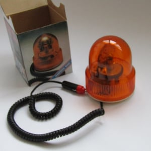 May include: An orange flashing beacon with a black coiled cord and a cigarette lighter plug. The beacon is in a cardboard box.