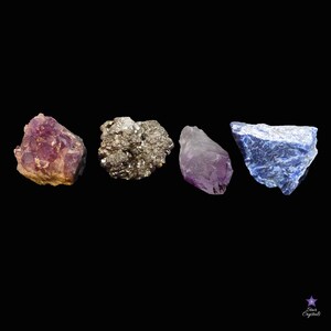 May include: Four rough, natural crystals: a purple amethyst, a gray pyrite, a purple amethyst, and a blue lapis lazuli.