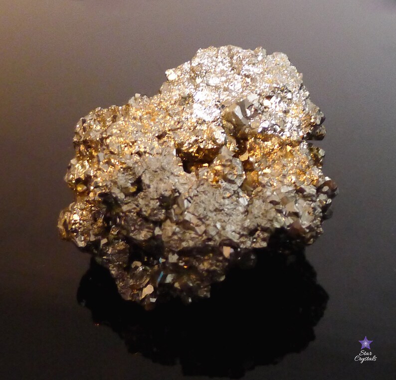 May include: A large, rough, gold and silver pyrite crystal cluster. The crystal has a metallic sheen and is composed of many smaller crystals.