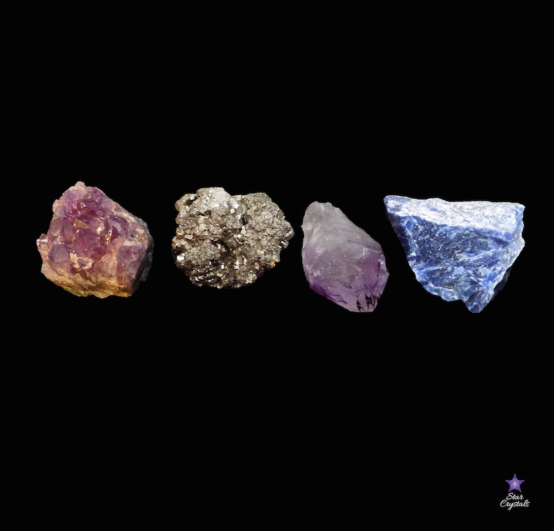 May include: Four rough, natural crystals: a purple amethyst, a gray pyrite, a purple amethyst, and a blue lapis lazuli.