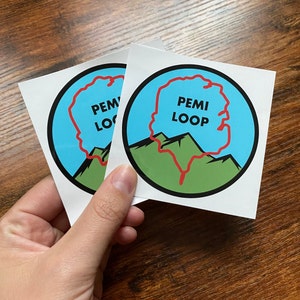 May include: Two white stickers with a red outline of a hiking trail. The top sticker says "Pem Loop" in black text. The bottom sticker says "Pem Loop" in black text.