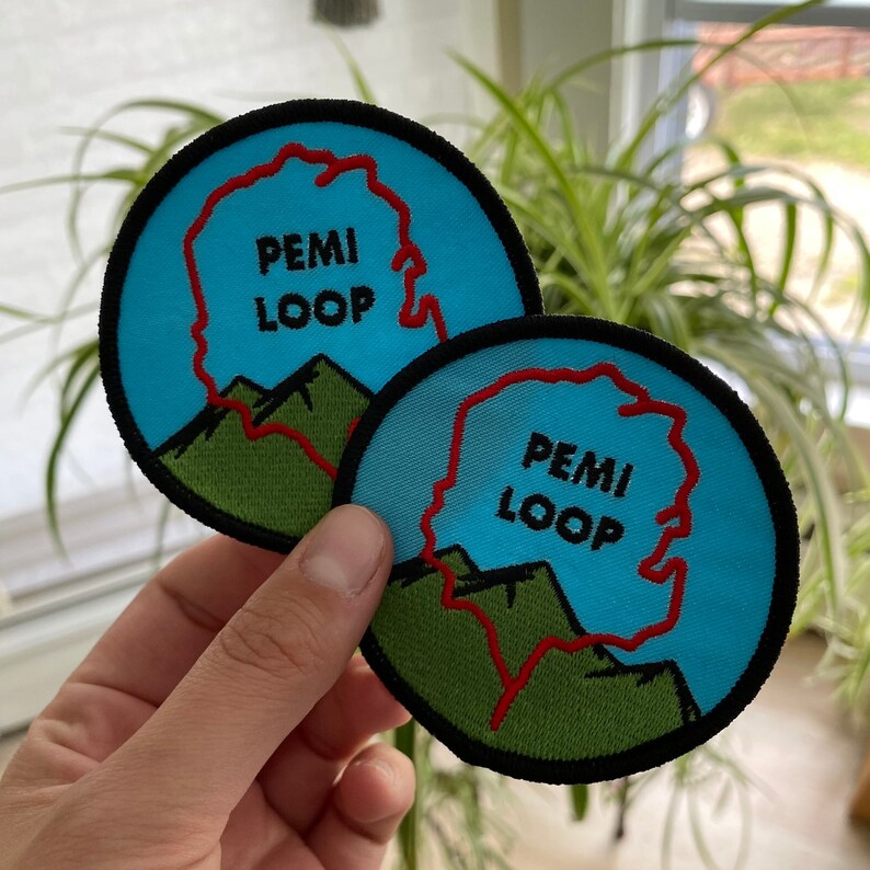 Pode incluir: Dois patches bordados azuis e verdes com o texto "PemI Loop" em letras pretas. O la&ccedil;o est&aacute; destacado em vermelho.