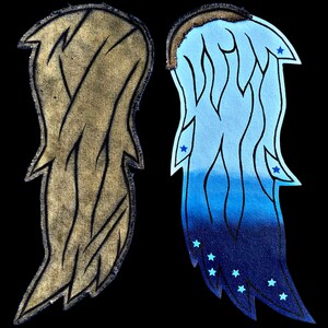 Op de afbeelding: Twee stoffen vleugels, een bruin en een blauw met een witte en blauwe ombre. De blauwe vleugel heeft blauwe sterren erop.