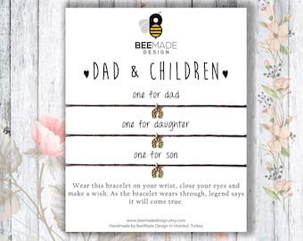 Puede incluir: Una tarjeta blanca con el texto "DAD & CHILDREN" y tres pulseras con dijes. Las pulseras están etiquetadas como "one for dad", "one for daughter" y "one for son". La tarjeta también incluye el texto "Wear this bracelet on your wrist, close your eyes and make a wish. As the bracelet wears through, legend says it will come true." y la dirección del sitio web "www.beemadedesign.etsy.com".