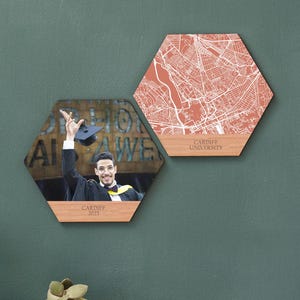 Puede incluir: Dos piezas hexagonales de arte mural. Una presenta una foto de un graduado, la otra un mapa de la Universidad de Cardiff. Ambas tienen bases de madera y están montadas en una pared verde azulado. La pieza fotográfica tiene el texto "Cardiff 2023". La pieza del mapa tiene el texto "Cardiff University".