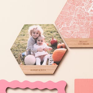 Modern illustrated map wall in solid colours and cherry wood, partnered with a custom photo tile – ideal personalised map present for marking anniversaries or travel memories.