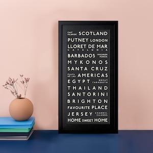 Puede incluir: Impresión enmarcada en blanco y negro con una lista de lugares, que incluyen Escocia, Putney Londres, Lloret de Mar, Cataluña, Barbados, Mykonos, Santa Cruz, América, Egipto, Tailandia, Santorini, Brighton, Lugar favorito, Jersey y Hogar dulce hogar.