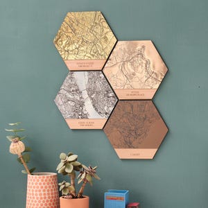 May include: Five hexagonal wooden wall decor pieces with engraved maps and text. The maps are in shades of brown, gold, and silver. The text reads "Home is where the heart is", "Ferry across the Mersey", "St Ives my happy place", and "Cardiff".