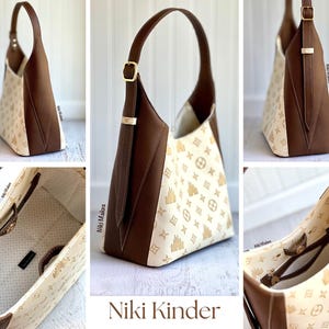 May include: A brown and cream-colored shoulder bag with a gold buckle and strap. The bag features a repeating pattern of gold icons on the cream-colored fabric. The bag has a brown leather strap and trim. The text "Niki Kinder" is at the bottom.