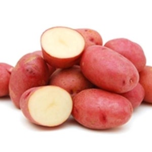 May include: A pile of fresh red potatoes, some whole and some cut in half, revealing a creamy interior. The potatoes have a smooth, reddish-pink skin and are set against a white background.