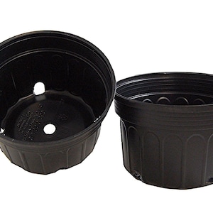 May include: Two black plastic plant pots. The pots have drainage holes and a ridged design around the top. One pot is tilted, showing the interior and drainage holes. The other pot is upright.