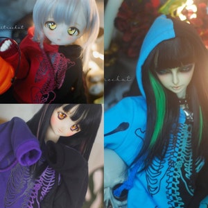 May include: Four different dolls wearing hoodies with a skeleton graphic design. The hoodies are in different colours, including blue, purple, black, and red. The dolls have different hair colours and styles.